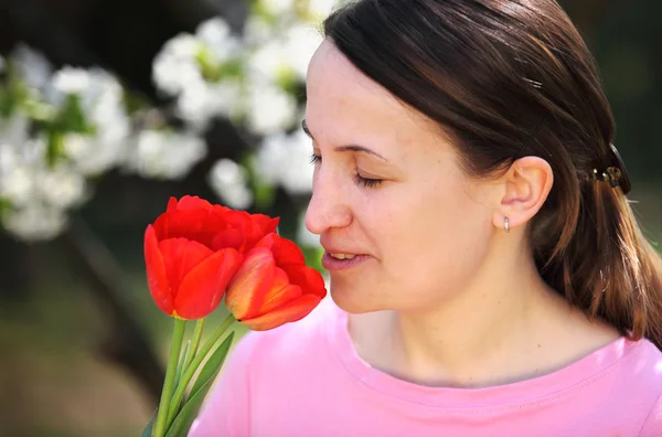 Smelling red tulips — Stock Photo, Image
