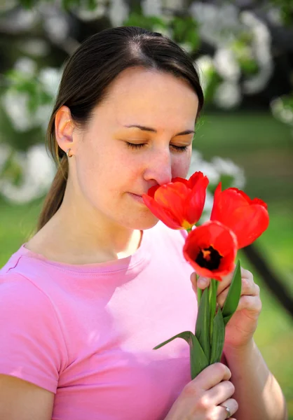 Smelling red tulips — Stock Photo, Image
