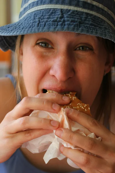 Junge Frau isst Hamburger — Stockfoto