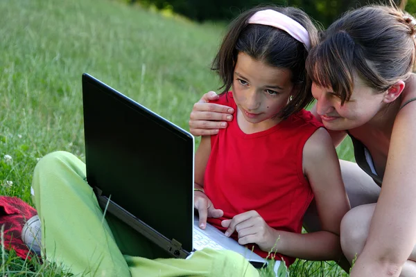 Sisters with laptop outdoor — Stock Photo, Image