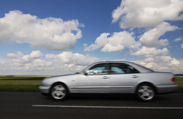 Дорога, автомобиль, голубое облачное небо — стоковое фото