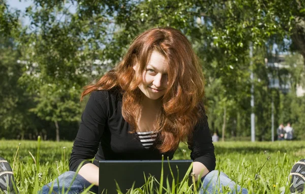 На траве с ноутбуком — стоковое фото