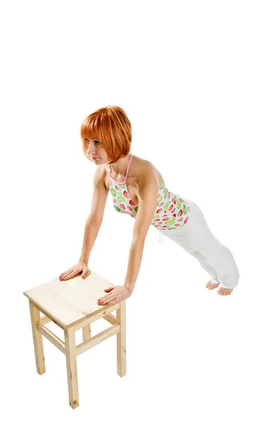 Red haired meisje uitvoeren van fitness oefeningen — Stockfoto