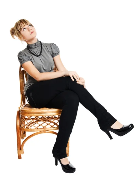 Молодая женщина, сидящая на стуле — стоковое фото