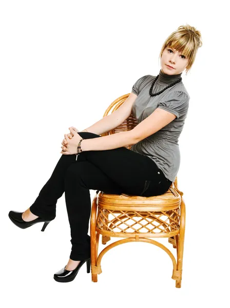 Νεαρή γυναίκα κάθεται σε μια καρέκλα — Φωτογραφία Αρχείου