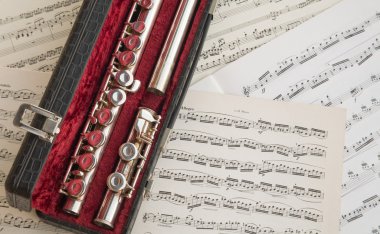 C flute over music scores clipart