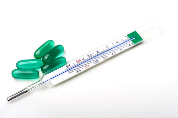 stock image Medical thermometer with flu pills