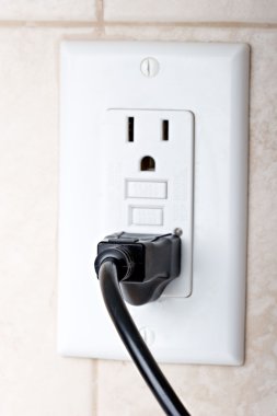 Power cord plugged in a wall socket clipart