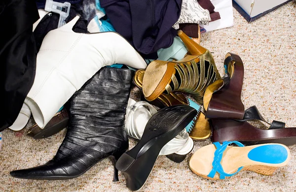Обувь на загроможденном грязном полу в шкафу — стоковое фото