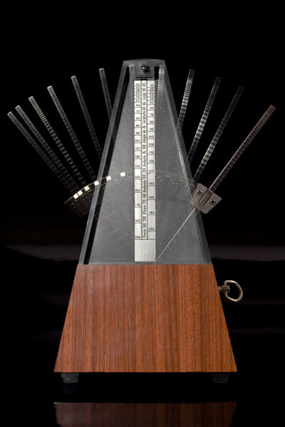 Классический деревянный метроном в движении
