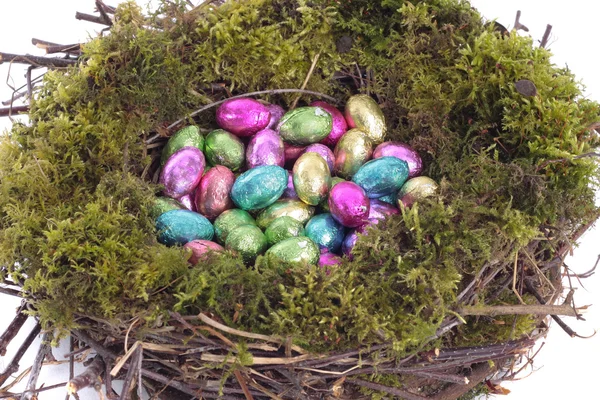 Ovos dourados em ninho de pássaro sobre branco — Fotografia de Stock