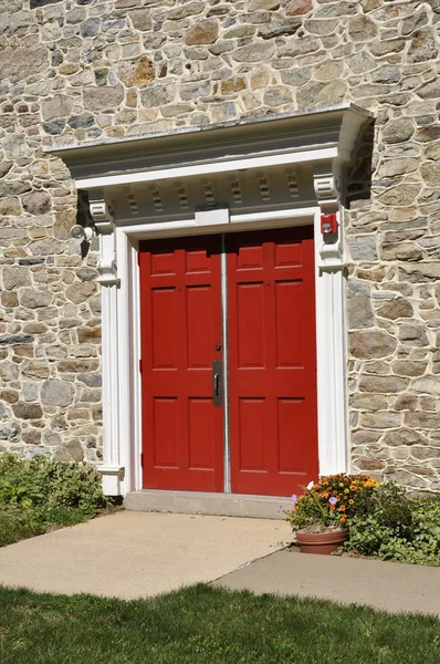 Stone church and red doors — Stock Photo, Image