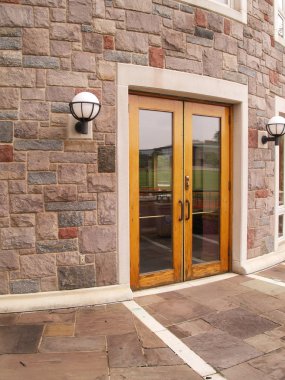 Wood doors by a stone building clipart