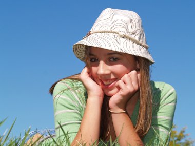 Teenage girl laying in the grass clipart