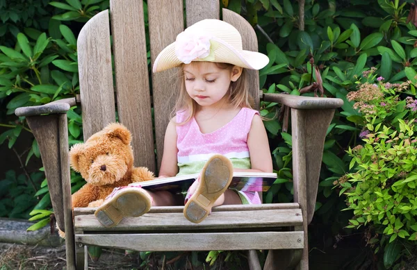 Criança leitura para ursinho de pelúcia — Fotografia de Stock