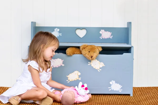 Criança brincando por uma caixa de brinquedos — Fotografia de Stock