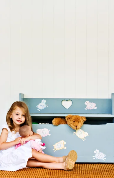 Criança brincando por uma caixa de brinquedos — Fotografia de Stock