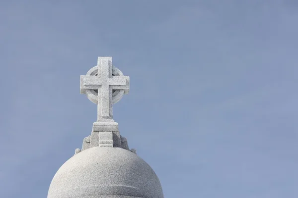 Kamenný kříž náhrobní kámen, na modré obloze — Stock fotografie