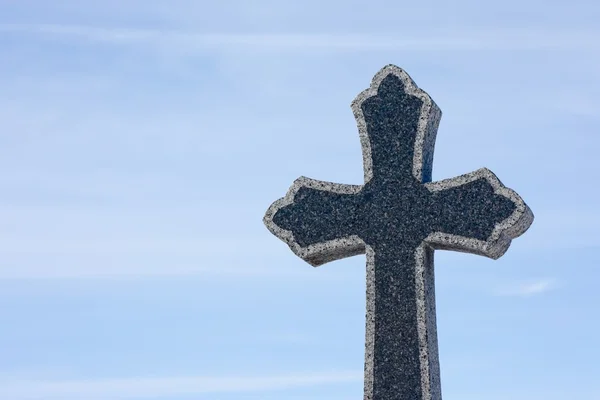 Kamenný kříž náhrobní kámen, na modré obloze — Stock fotografie