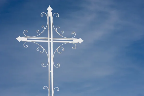 Wrought iron cross on blue sky — Zdjęcie stockowe
