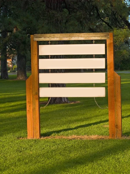Placas de madeira em branco em um parque iluminado pelo sol — Fotografia de Stock