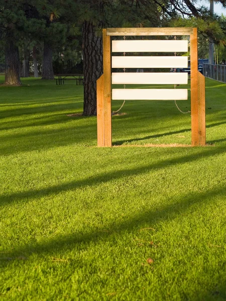 Signos de madera en blanco en un parque iluminado por el sol —  Fotos de Stock