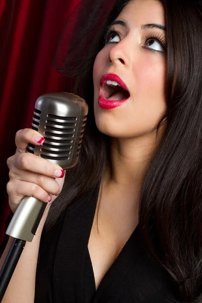 Woman singing into vintage microphone — Stock Photo, Image