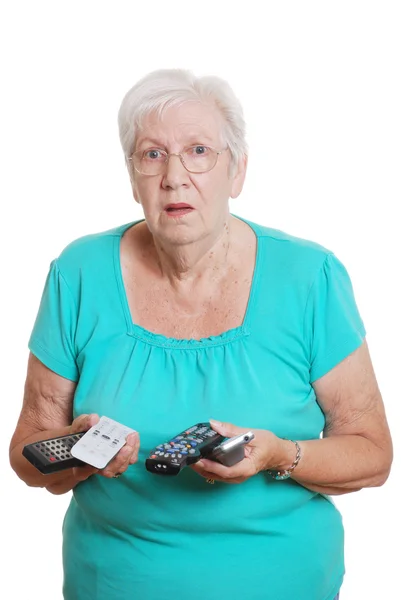 Woman confused with lots of tv remotes — Stock Photo, Image