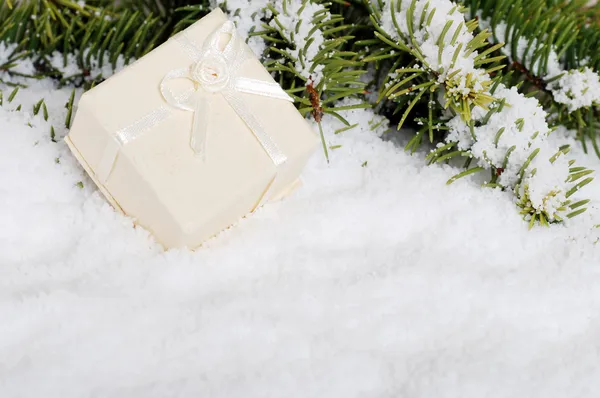 Beige Weihnachtsgeschenk im Schnee — Stockfoto