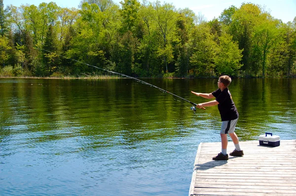 Rapaz a pescar numa doca — Fotografia de Stock