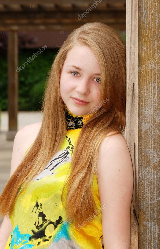 Blond female teen leaning on a wood pill — Stock Photo © mcgphoto #2384426