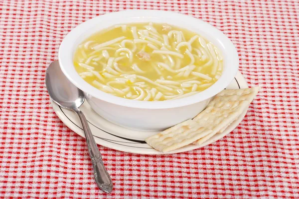 Куриный суп с лапшой с ложкой и крэком — стоковое фото