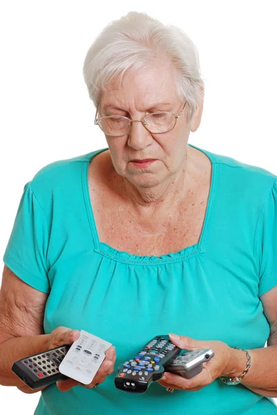 stock image Senior woman confused with many remotes