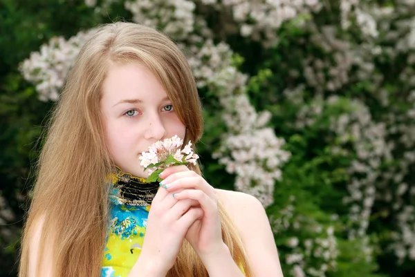 Jonge vrouwelijke tiener ruikende bloemen — Stockfoto