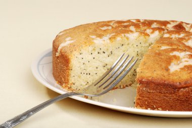 Cut lemon poppy seed cake with a fork clipart