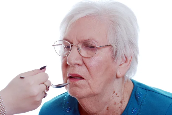 Elderly woman being given medicine — Stock Photo, Image