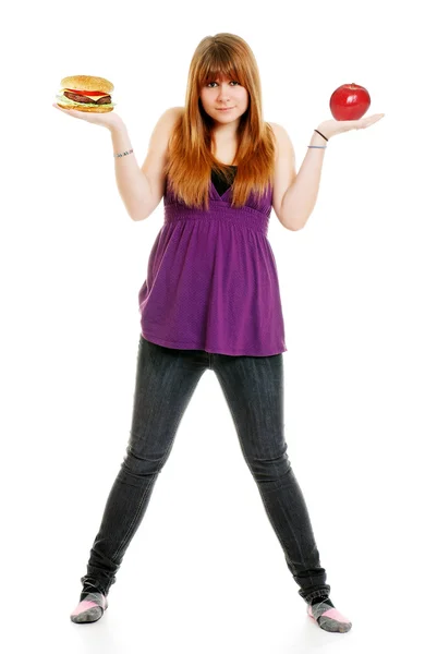 Adolescente decidindo hambúrguer ou maçã — Fotografia de Stock