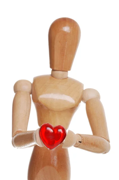 Wood figure holding pastic red heart — Stock Photo, Image