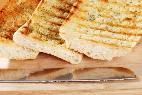 Closeup garlic bread with knife — Stock Photo, Image
