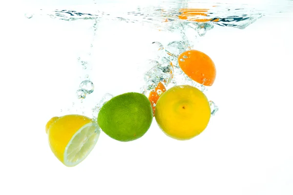 Citrus fruit falling into clear water — Stock Photo, Image