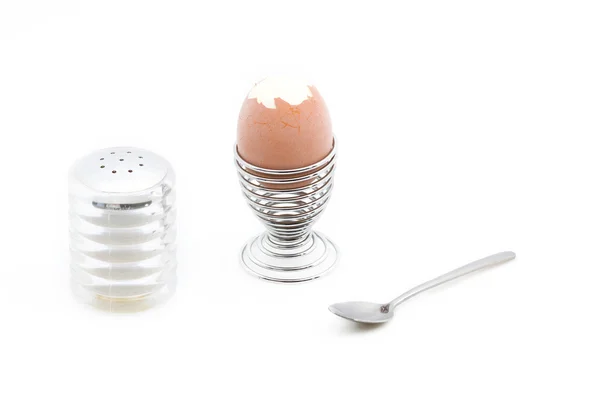 Een eggcup met een ontvelde ei naast een sa — Stockfoto