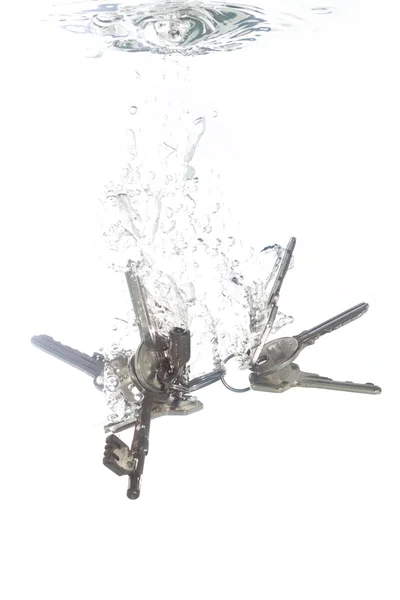 Um chaveiro caindo em água limpa — Fotografia de Stock