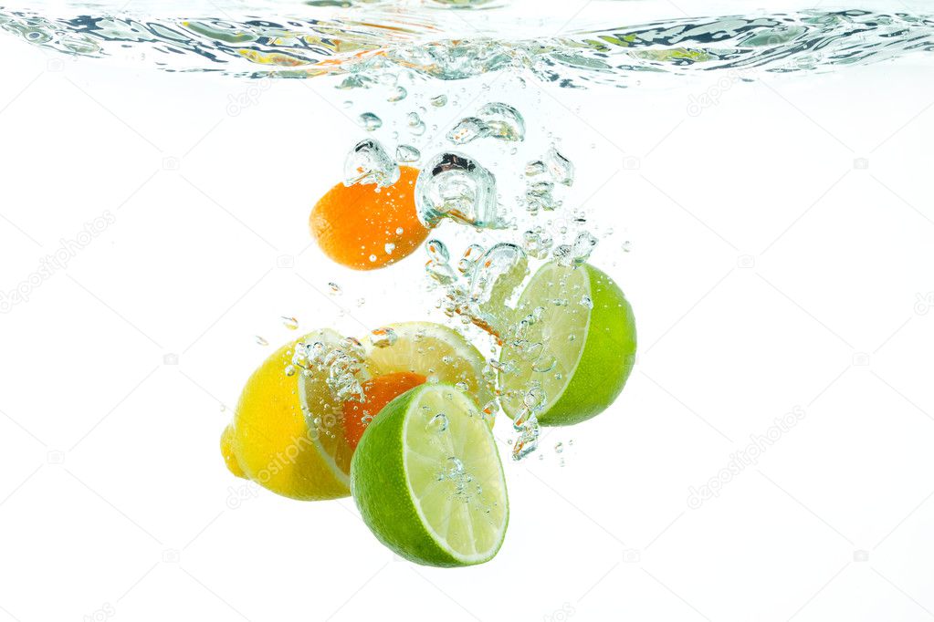 Citrus fruit falling into clear water