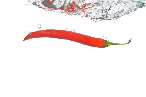 stock image Chili pepper falling into clear water