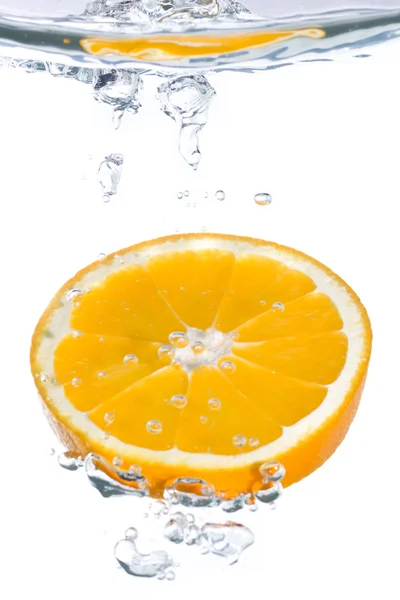 An orange slice falling into clear water — Stock Photo, Image