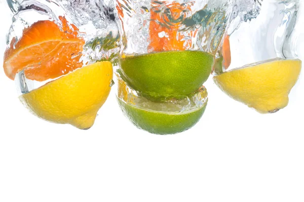 Цитрусовые фрукты падают в чистую воду — стоковое фото