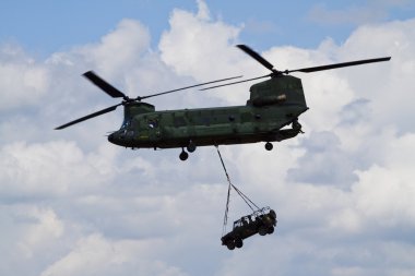 A chinook helicopter carrying a jeep clipart