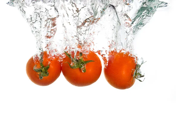 3 помідори падають у чисту воду — стокове фото