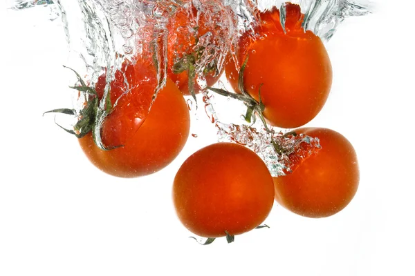 Tomates que caen en agua clara — Foto de Stock