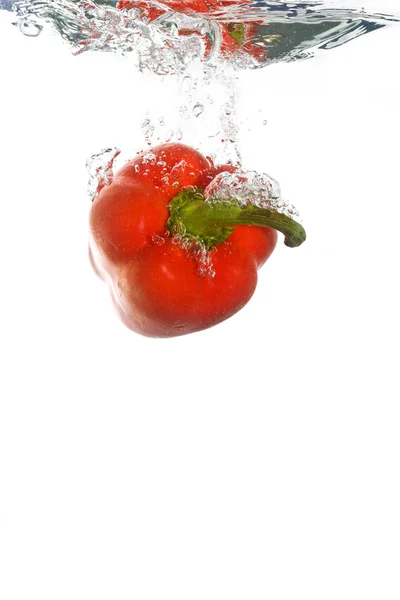 A paprika falling into clear water — Stock Photo, Image